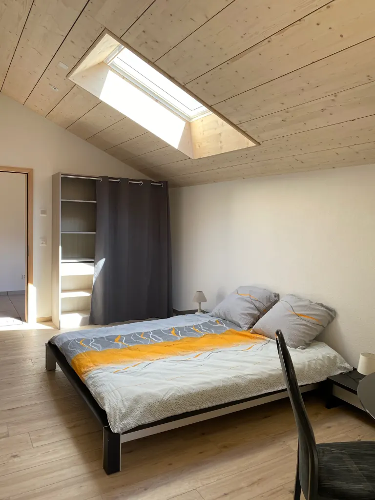 Lit double sous le velux, avec bibliothèque et rideau